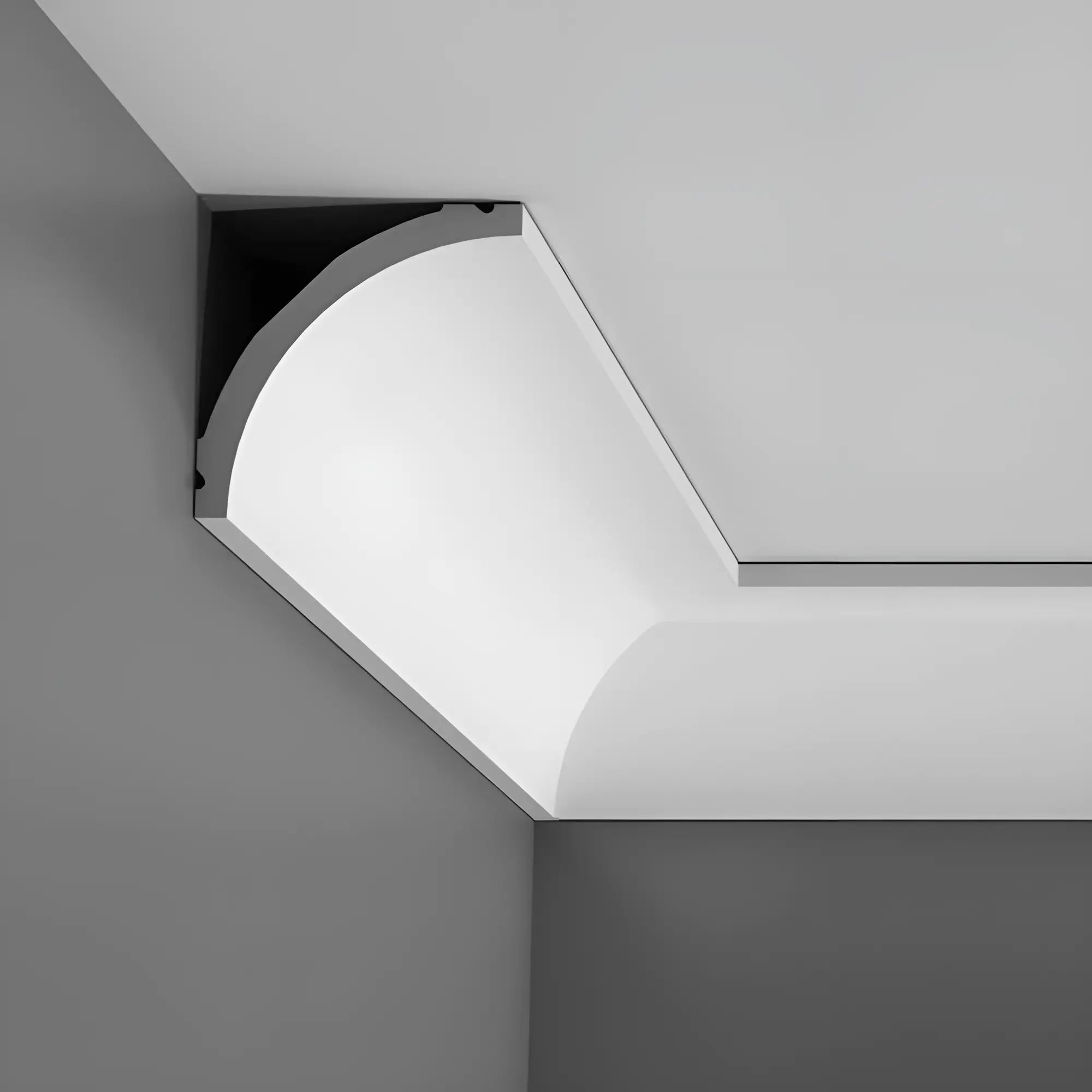 Ein modernes, minimalistisches Deckendetail mit einer glatten, geschwungenen C240 Stuckleiste von Orac Decor im Material Purotouch, die einen Kontrast zu dunkelgrauen Wänden bildet und zeitgenössische Innenräume und architektonisches Design hervorhebt.
