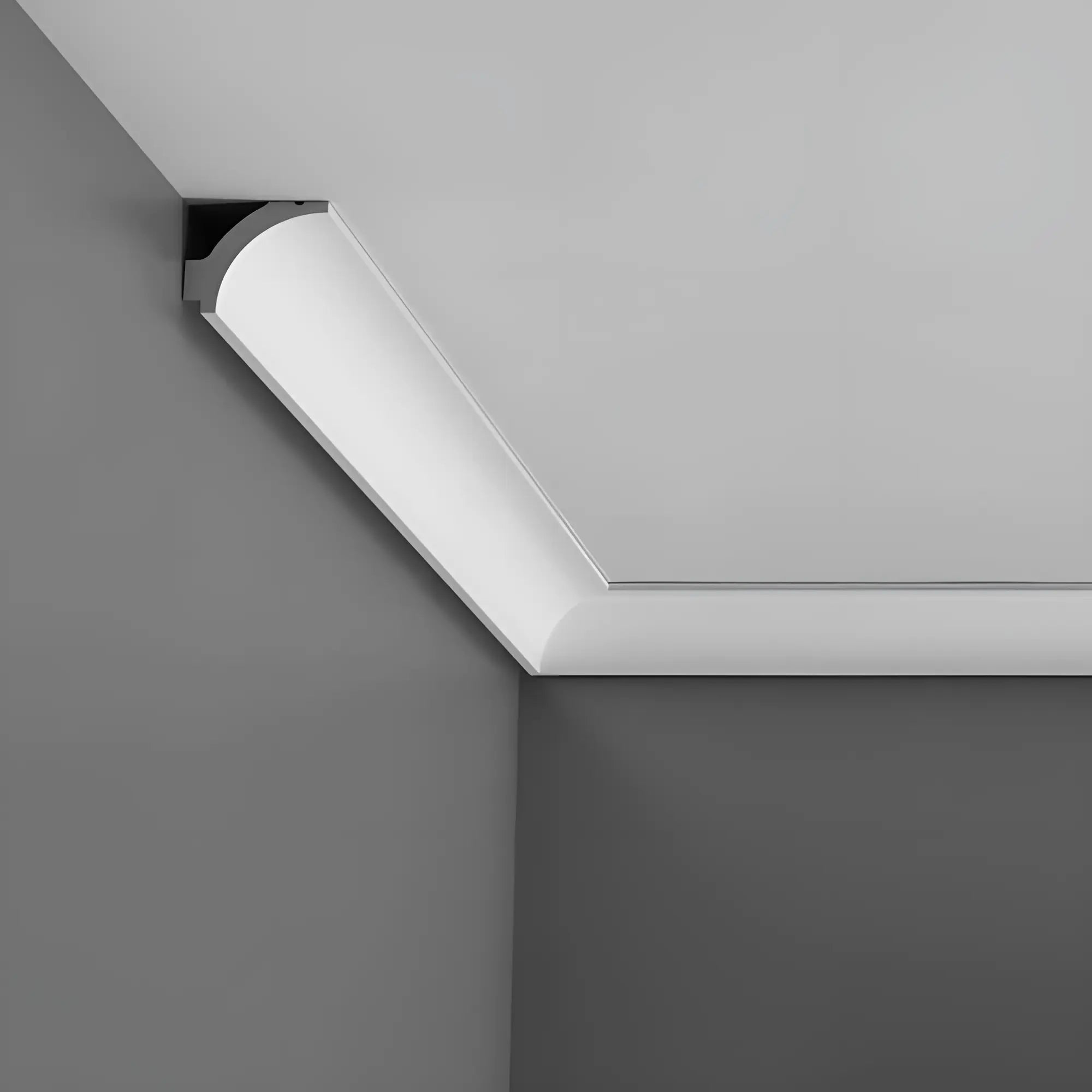 Eine weiße Stückleiste von Orac Decor aus Purotouch mit sanfter Beleuchtung ist in der Ecke einer grauen Raumgestaltung angebracht und betont den Übergang zwischen Decke und Wänden.